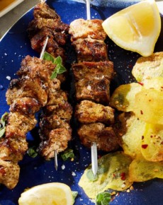 Souflaki mit Kartoffelchips und Zitronenspalten